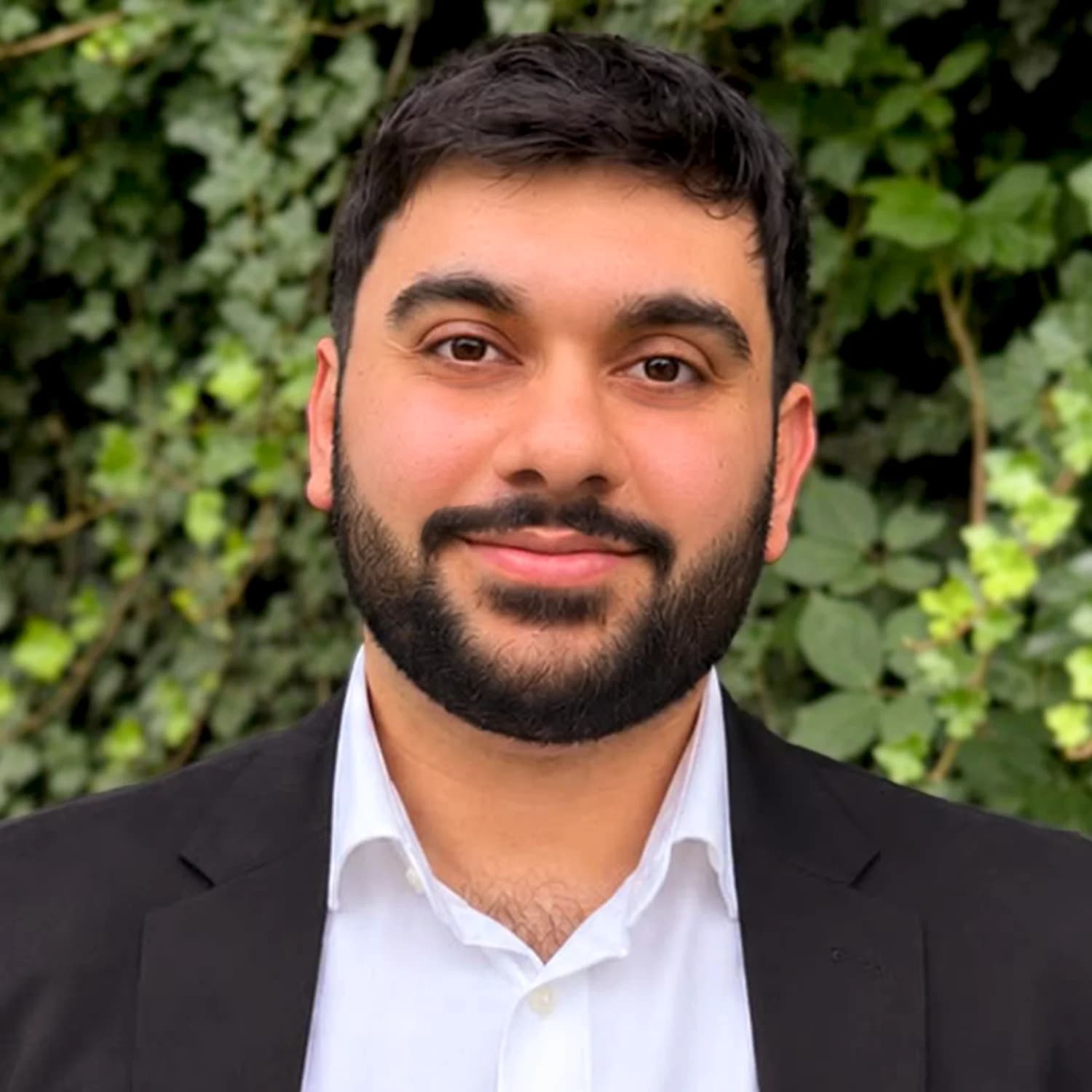 Mert Sirin, Gründer von supnature, im Porträt vor grünem Blattwerk.